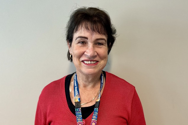 A woman in a red cardigan smiling.